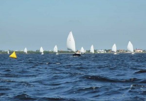 From left: Odd Duck in the distance, still trying to round the windward mark, then Frisky, Sunday Cat, Indy Anna, Suitsus, Wily Conch, Sea Bird, Catnip and Good Juju. Fleet Approaching Reach Mark